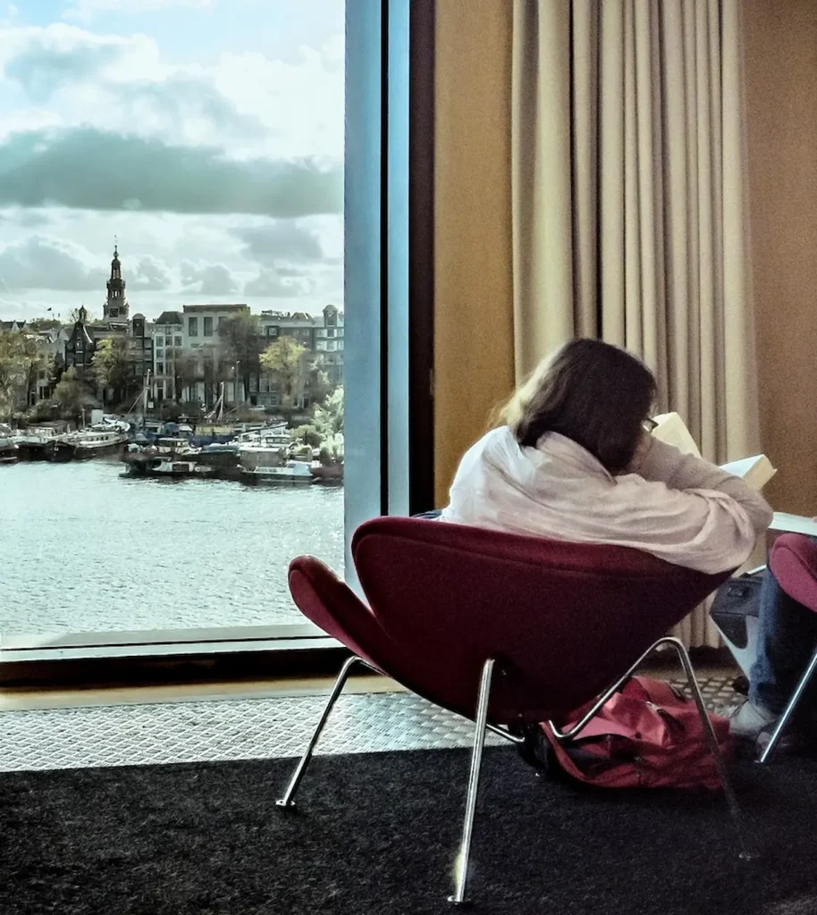 Pessoa observando a cidade de Amsterdã pela janela